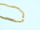 a close up of a gold chain bracelet on a blue background