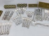 a lot of silver spoons and forks on a table