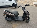 a scooter parked in a parking lot next to a van