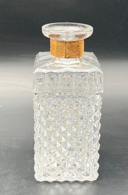 a clear glass bottle with a gold lid