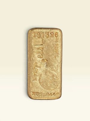 un lingot d'or posé sur une surface blanche, sur fond blanc