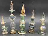 seven glass candlesticks sitting next to each other on a table