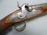 an old gun with a wooden handle on a white surface