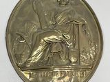 an image of a gold medal with a woman sitting on a chair