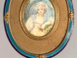 an image of a picture of a woman in a blue dress on a gold stand