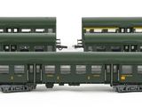 three green train cars sitting next to each other on a white surface