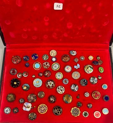 une boîte rouge remplie d'une multitude de broches de toutes sortes