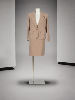 une robe et une veste posées sur un mannequin dans une pièce