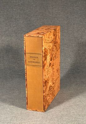 an old book sitting on top of a wooden box on a table