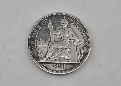 a silver coin with a statue of liberty on it