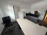 un bureau avec un écran et une chaise dans une pièce