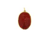 un pendentif en or avec une pierre rouge au centre