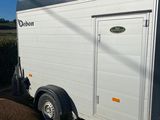 a white trailer parked in a gravel lot