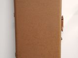a brown suitcase sitting on the floor next to a white wall
