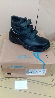 black leather shoes with velcro straps on top of a cardboard box