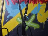 deux trottinettes électriques garées l'une à côté de l'autre devant un mur recouvert de graffitis