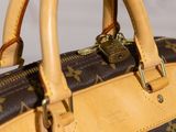 a brown and tan handbag with a lock on it