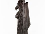 a bronze statue of a woman in a cloak and cloak