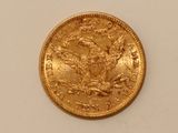 a close up of a gold coin on a white surface