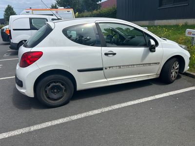 a small white car that is parked in a parking lot