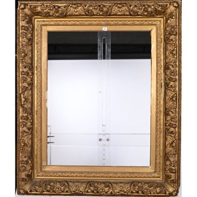 un miroir au cadre doré ouvragé, muni d'une porte en verre transparent