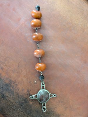 a close up of a necklace with a cross on it