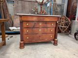 a wooden dresser with a marble top in the middle of a room