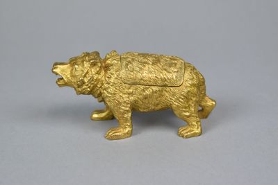 a gold bear figurine on a gray surface