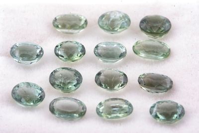 Des améthystes vertes sont disposées sur une surface blanche
