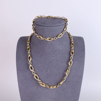 un ensemble composé d'un collier et d'un bracelet en chaîne d'or, présenté sur un mannequin
