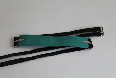 une paire de sangles élastiques vertes et noires sur un fond blanc