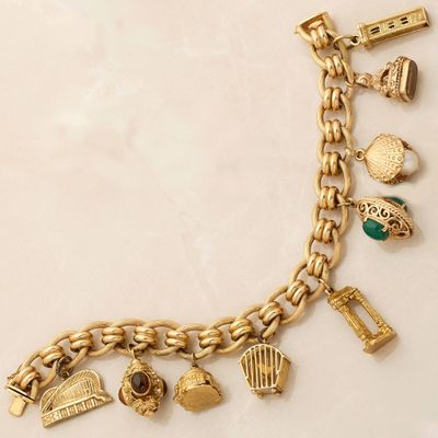 an image of a gold bracelet with charms on a white surface