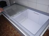 une personne ouvrant un congélateur dans une cuisine