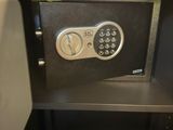 a small safe box on a shelf in a room