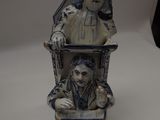 a figurine of a man and a woman sitting on a chair