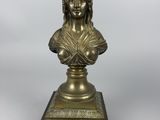 a bronze bust of a woman on a pedestal with a white background