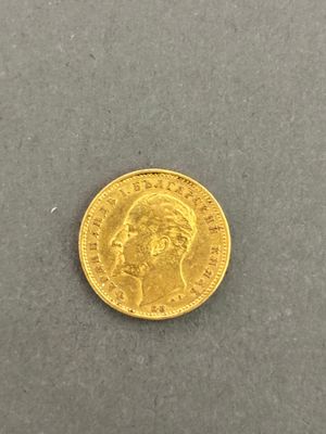 a close up of a gold coin on a gray surface