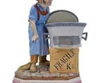 figurine of a woman cooking a pot of food on a stove