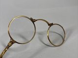 someone holding a pair of glasses on a table with a white background