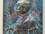 an image of a bronze plaque of a man in a suit and tie
