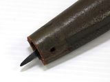 a small metal object with a black handle on a white surface