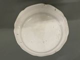a white plate on a table with a black background