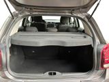 the back of a silver car with its trunk open and the seats folded down