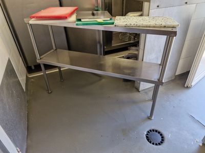 une table en acier inoxydable dans une cuisine équipée d'un évier