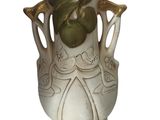 un vase blanc orné d'une feuille verte