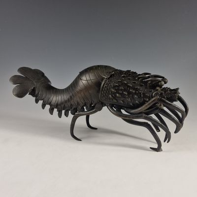 une statue en bronze représentant un homard avec de grandes pinces sur le dos