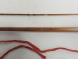 a close up of a wooden fishing rod with a red string