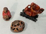 trois figurines posées les unes à côté des autres sur une surface blanche
