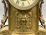 a gold clock that is sitting on top of a table