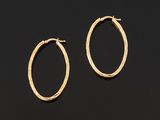 a pair of gold hoop earrings on a black background